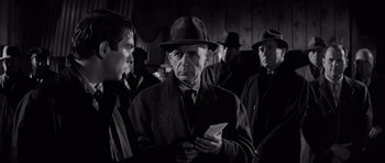 Movie still from “In Cold Blood” (1967), directed by Richard Brooks – An older man in a hat and a coat; Close Up shot, Over the shoulder angle