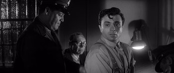 Movie still from “In Cold Blood” (1967), directed by Richard Brooks – A black - and - white photo of a man in a police uniform; Close Up shot, Low angle