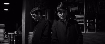 Movie still from “In Cold Blood” (1967), directed by Richard Brooks – A man in a hat and a man in a suit; Medium shot, Low angle
