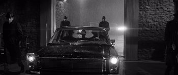 Movie still from “In Cold Blood” (1967), directed by Richard Brooks – A group of men standing next to each other in the back of a car; Wide shot, Low angle