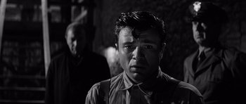 Movie still from “In Cold Blood” (1967), directed by Richard Brooks – A man in a black and white photo looking at the camera; Close Up shot, Low angle