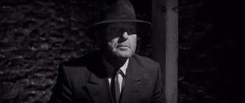 Movie still from “In Cold Blood” (1967), directed by Richard Brooks – A man wearing a suit and a hat; Close Up shot, Low angle