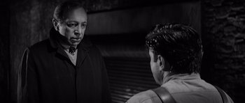 Movie still from “In Cold Blood” (1967), directed by Richard Brooks – A man and a woman are standing next to each other; Close Up shot, Over the shoulder angle