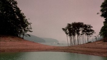 Movie still from “In Dreams” (1999), directed by Neil Jordan – A body of water surrounded by trees and a body of water; Extreme Wide shot, High angle