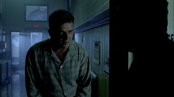 Movie still from “In Dreams” (1999), directed by Neil Jordan – A man standing in a dark room next to an oven; Medium shot, Low angle