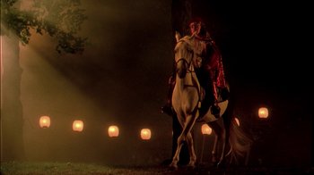 Movie still from “In Dreams” (1999), directed by Neil Jordan – A man riding on the back of a white horse at night; Wide shot, Low angle