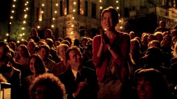 Movie still from “In Dreams” (1999), directed by Neil Jordan – A woman clapping in front of a crowd of people; Medium shot, Over the shoulder angle