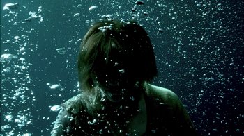 Movie still from “In Dreams” (1999), directed by Neil Jordan – A woman in the water under a body of water; Close Up shot, Overhead angle