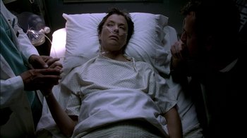 Movie still from “In Dreams” (1999), directed by Neil Jordan – A woman laying in a hospital bed next to a man; Close Up shot, High angle