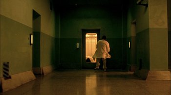 Movie still from “In Dreams” (1999), directed by Neil Jordan – A man in a white robe walking through a hallway; Wide shot, Low angle