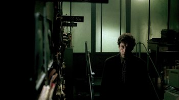 Movie still from “In Dreams” (1999), directed by Neil Jordan – A man wearing a suit and tie standing in a room; Medium shot, Low angle