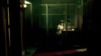 Movie still from “In Dreams” (1999), directed by Neil Jordan – A man sitting at a table in front of a lamp; Wide shot, High angle