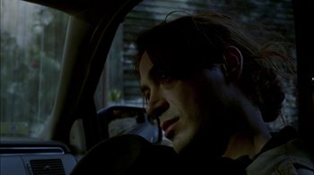 Movie still from “In Dreams” (1999), directed by Neil Jordan – A man sitting in the driver's seat of a car; Close Up shot, Over the shoulder angle