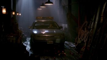Movie still from “In Dreams” (1999), directed by Neil Jordan – A man sitting in the drivers seat of a car in a garage; Wide shot, Low angle