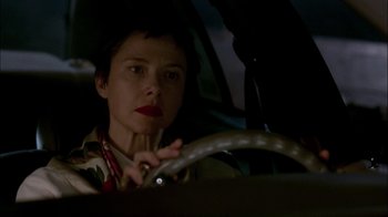 Movie still from “In Dreams” (1999), directed by Neil Jordan – A woman sitting in the driver's seat of a car at night; Close Up shot, Low angle