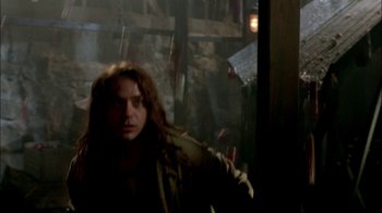 Movie still from “In Dreams” (1999), directed by Neil Jordan – A man with long red hair standing next to a window; Medium shot, Over the shoulder angle