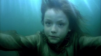 Movie still from “In Dreams” (1999), directed by Neil Jordan – A young girl is swimming underwater in a body of water; Close Up shot, High angle