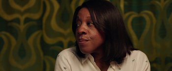 Movie still from “In Fabric” (2018), directed by Peter Strickland – A person wearing a white shirt; Close Up shot, Over the shoulder angle