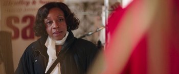 Movie still from “In Fabric” (2018), directed by Peter Strickland – A person wearing a black jacket; Close Up shot, Over the shoulder angle