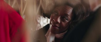 Movie still from “In Fabric” (2018), directed by Peter Strickland – A person wearing a suit and tie; Close Up shot, Low angle