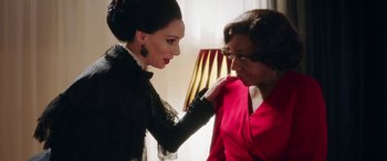 Movie still from “In Fabric” (2018), directed by Peter Strickland – A woman adjusting the collar of another woman's dress; Close Up shot, Over the shoulder angle