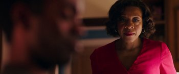 Movie still from “In Fabric” (2018), directed by Peter Strickland – A woman in a red shirt is looking at a man in a black suit; Close Up shot, Over the shoulder angle