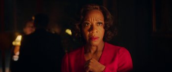 Movie still from “In Fabric” (2018), directed by Peter Strickland – An older woman in a red jacket looking at the camera; Close Up shot, Over the shoulder angle