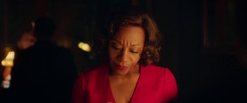 Movie still from “In Fabric” (2018), directed by Peter Strickland – A woman in a red shirt is looking down; Close Up shot, Over the shoulder angle