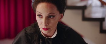 Movie still from “In Fabric” (2018), directed by Peter Strickland – A person wearing a black shirt; Close Up shot, Over the shoulder angle