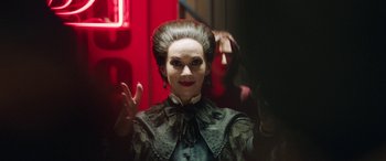 Movie still from “In Fabric” (2018), directed by Peter Strickland – A woman in a black and white dress with a red background; Close Up shot, Low angle