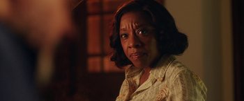 Movie still from “In Fabric” (2018), directed by Peter Strickland – An older woman is looking at the camera; Close Up shot, Over the shoulder angle