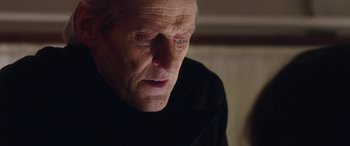 Movie still from “In Fabric” (2018), directed by Peter Strickland – An old man with a sad look on his face; Close Up shot, Over the shoulder angle
