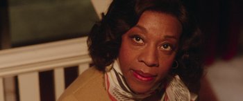 Movie still from “In Fabric” (2018), directed by Peter Strickland – An older woman is looking into the camera; Close Up shot, Low angle