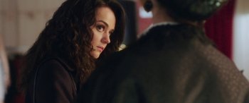 Movie still from “In Fabric” (2018), directed by Peter Strickland – A person sitting in front of another person; Close Up shot, Over the shoulder angle