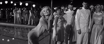 Movie still from “In Harm's Way” (1965), directed by Otto Preminger – Black and white photograph of a woman leaning on a pole; Medium shot, Low angle