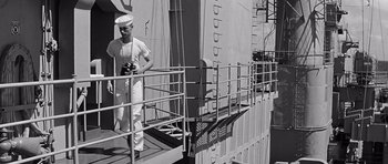 Movie still from “In Harm's Way” (1965), directed by Otto Preminger – A man standing on the deck of a boat; Medium shot, Low angle