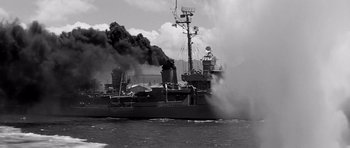 Movie still from “In Harm's Way” (1965), directed by Otto Preminger – A large boat with smoke coming out of it; Wide shot, Low angle