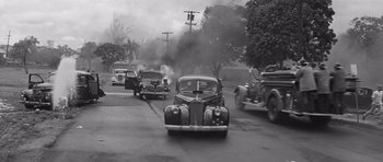 Movie still from “In Harm's Way” (1965), directed by Otto Preminger – An old car is driving down the street; Extreme Wide shot, High angle