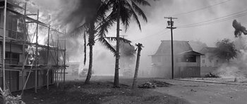 Movie still from “In Harm's Way” (1965), directed by Otto Preminger – Smoke billows from a fire in a residential area; Extreme Wide shot, Low angle