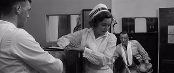 Movie still from “In Harm's Way” (1965), directed by Otto Preminger – An old photo of a woman wearing a nurse's uniform; Medium shot, Low angle