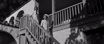 Movie still from “In Harm's Way” (1965), directed by Otto Preminger – Two young women walking down the stairs of a house; Wide shot, Low angle