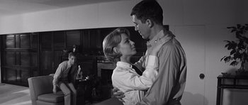 Movie still from “In Harm's Way” (1965), directed by Otto Preminger – A man and a woman embracing each other in front of a fireplace; Medium shot, Low angle