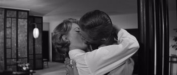 Movie still from “In Harm's Way” (1965), directed by Otto Preminger – A man and a woman kissing each other in front of a mirror; Close Up shot, Low angle