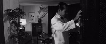 Movie still from “In Harm's Way” (1965), directed by Otto Preminger – A black and white photo of a man in a white shirt; Medium shot, Low angle