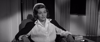 Movie still from “In Harm's Way” (1965), directed by Otto Preminger – An old photo of a woman wearing a nurse's uniform; Medium shot, Over the shoulder angle
