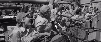 Movie still from “In Harm's Way” (1965), directed by Otto Preminger – A group of men and women standing next to each other; Medium shot, Low angle