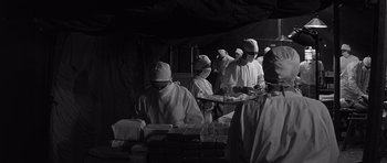 Movie still from “In Harm's Way” (1965), directed by Otto Preminger – A black and white photo of a group of people wearing surgical masks; Medium shot, Low angle