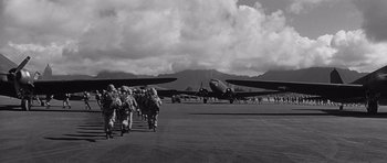 Movie still from “In Harm's Way” (1965), directed by Otto Preminger – A group of people walking across a runway; Extreme Wide shot, Low angle