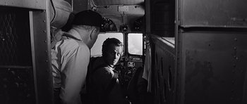 Movie still from “In Harm's Way” (1965), directed by Otto Preminger – Two men are in the cockpit of an airplane; Medium shot, Over the shoulder angle
