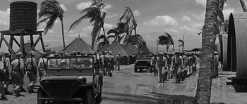 Movie still from “In Harm's Way” (1965), directed by Otto Preminger – A group of men standing next to tents on a beach; Extreme Wide shot, High angle